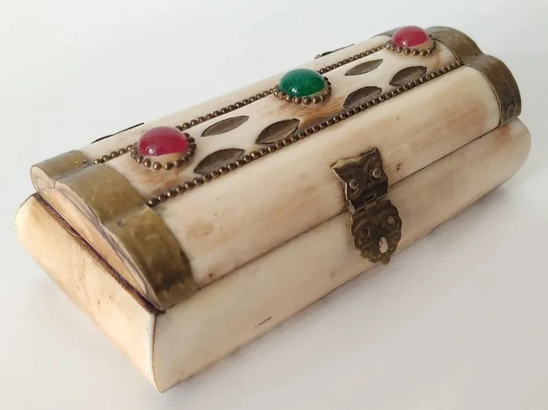 Boîte à bijoux ancienne en os, ornée de laiton et doublée de tissu lavande.