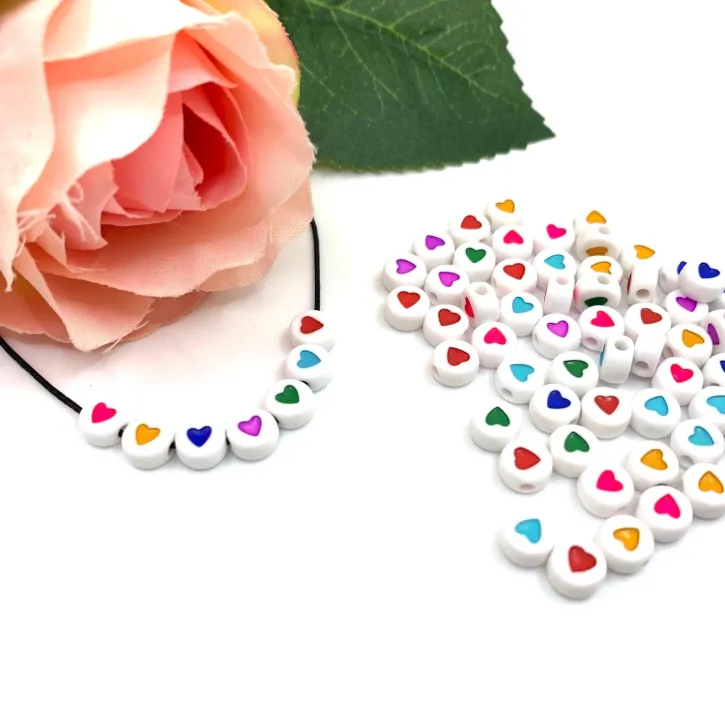 Perles rondes colorées avec motifs d'amour en acrylique pour création de bijoux.